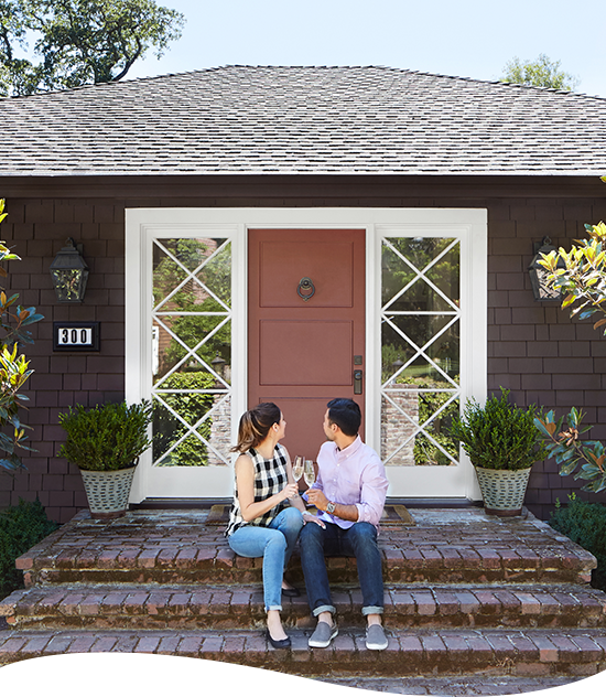 Couple sitting in front of their house