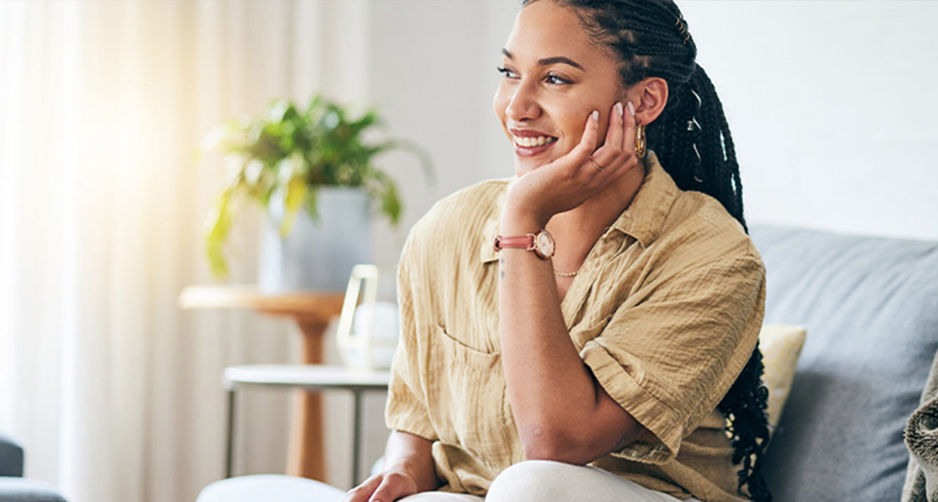 Woman sitting on couch, smiling. 