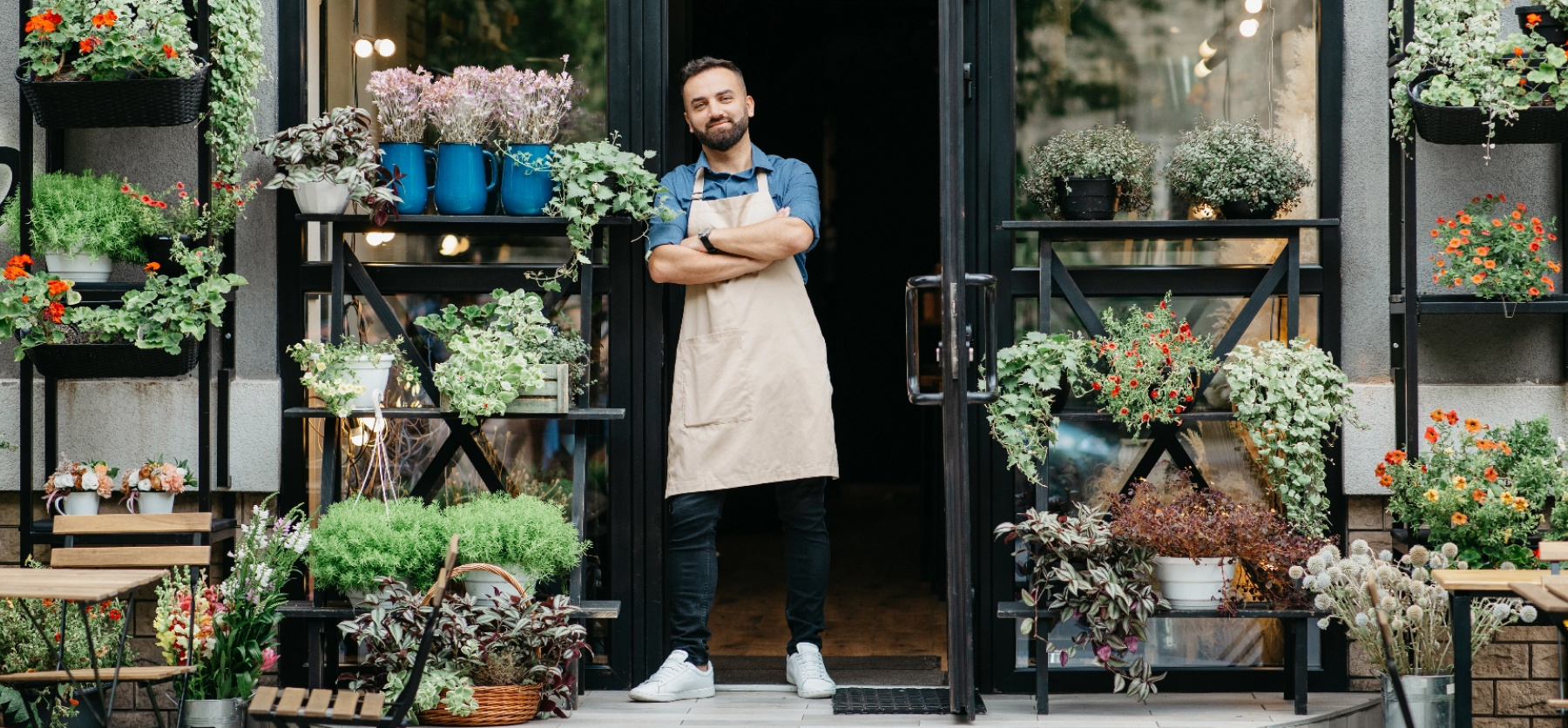 Business owner standing in storefront doorway