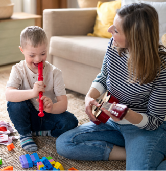 A young boy plays the recorder while a woman plays a ukulele 