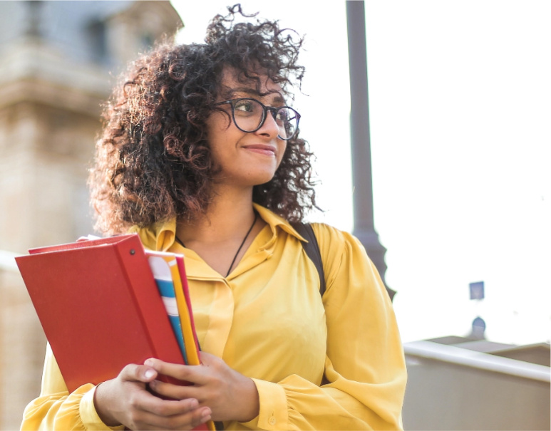 Student standing confidently holding books. 