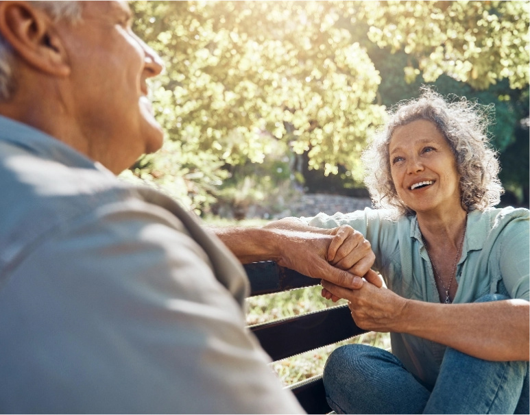 Older couple sitting on park bench.