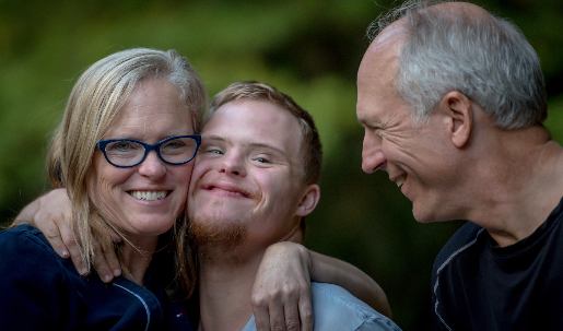 Mother and father with son, smiling and embracing. 