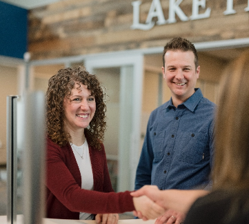 Members at branch shaking team member's hand. 