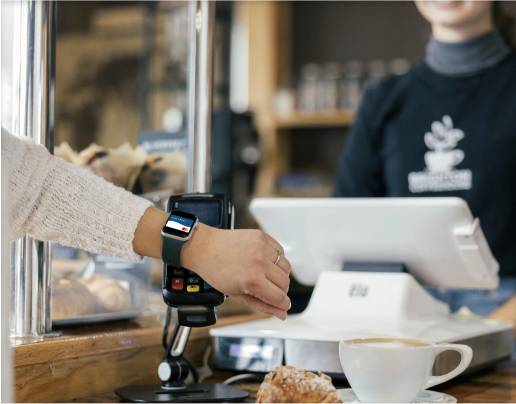 A person pays with their watch to buy a pastry and coffee at Brighton Coffeehouse