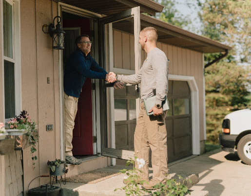 Colton, the owner of Hometown Plumbing, shakes hands with a man at the front of a house