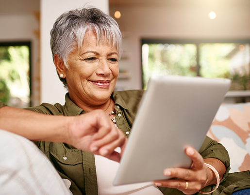 A woman with shirt, gray hair looks at a tablet