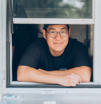 Brian, owner of Bao Boys Food Truck, looking out from Food Truck window.