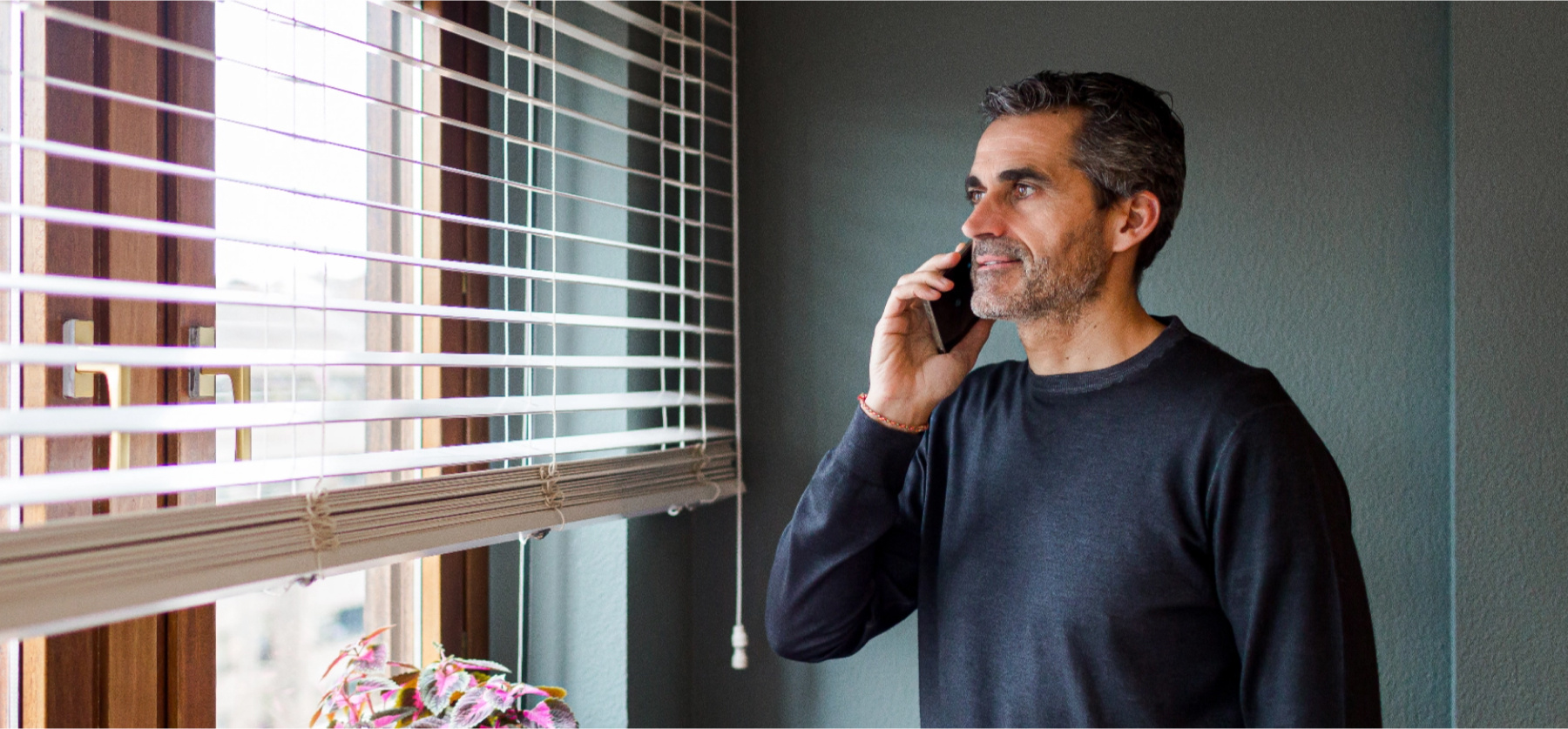 Man on cellphone staring out of window