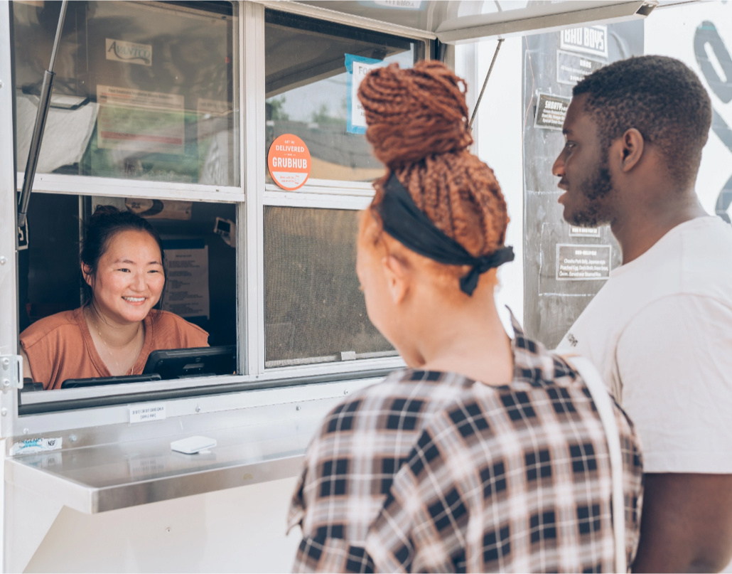 A Bao Boys employee takes an order from two customers 