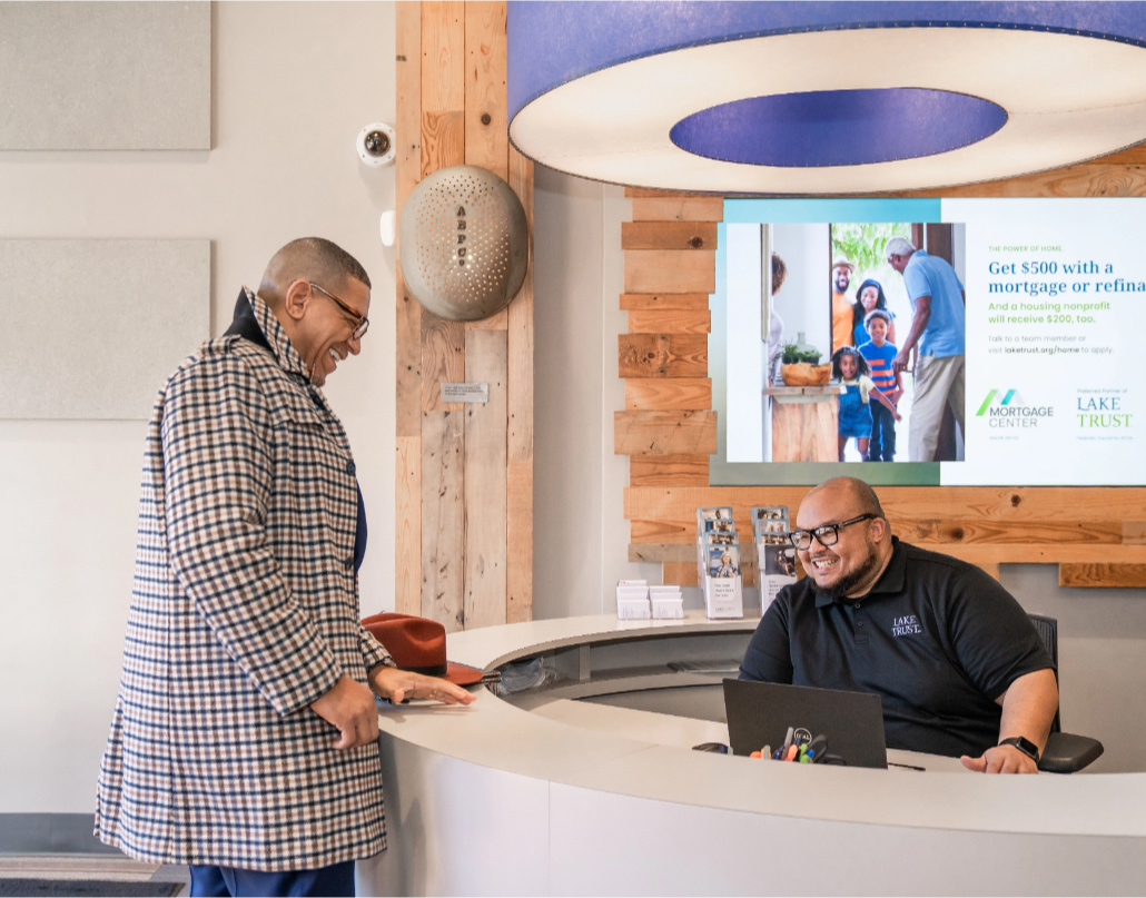 Ne'Gyle, the owner of Bleu Bowtique, speaks to a Lake Trust team member at a branch in Detroit