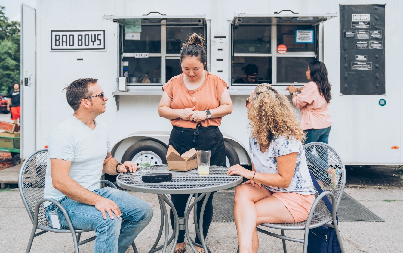 Customers sitting at table in front of Bao Boys Food Truck in Ann Arbor, Michigan.