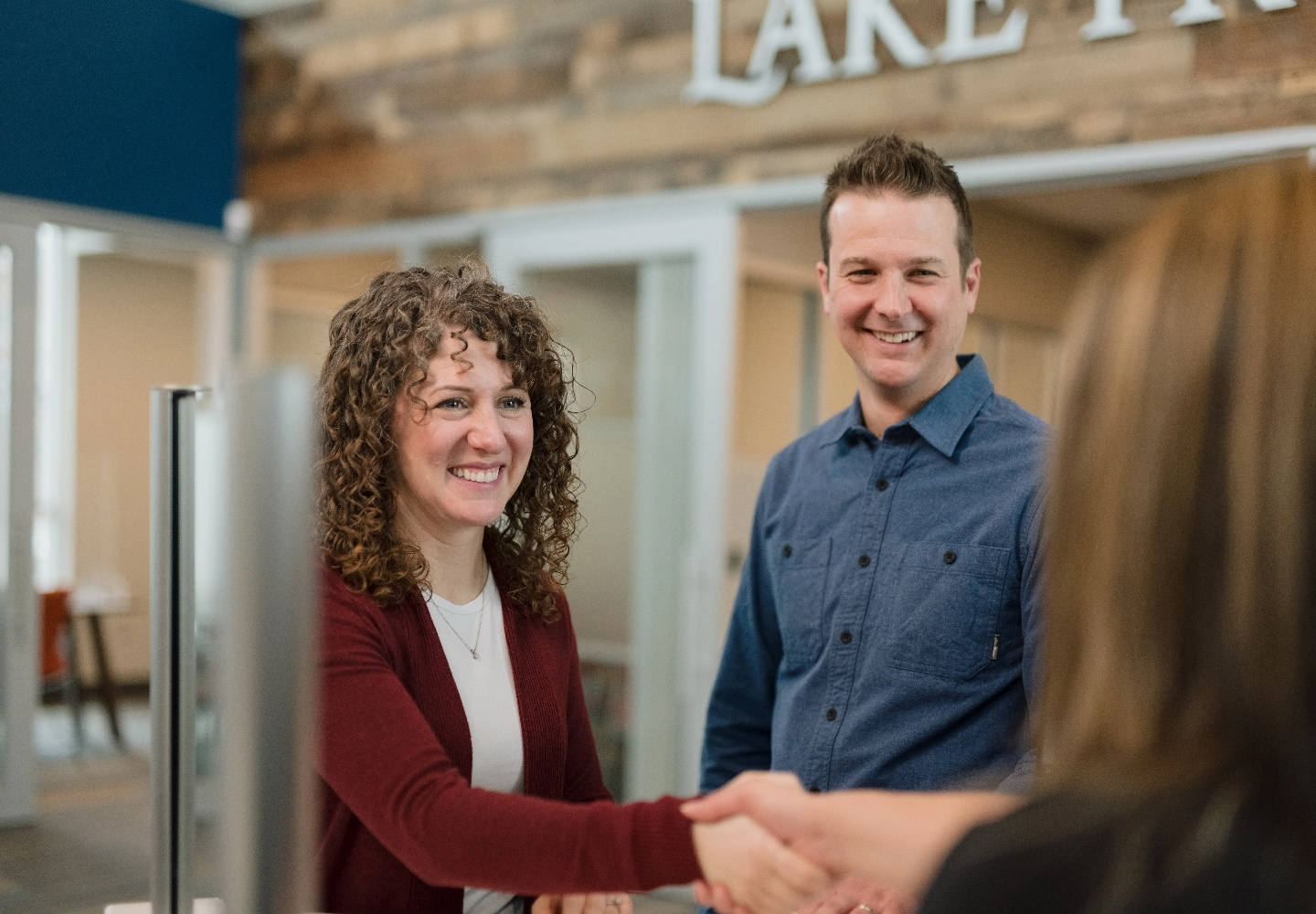 Corey, a Lake Trust member, and a woman with curly hair visit a branch