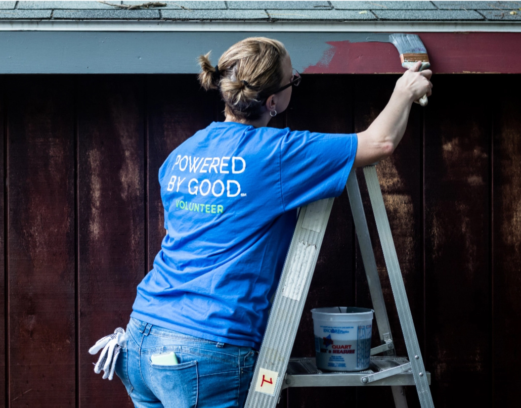 Lake Trust team members on ladder painting building