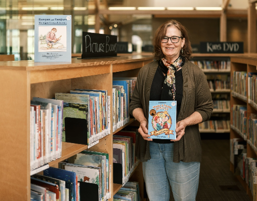 Kat, a Lake Trust member, holds a book in a library