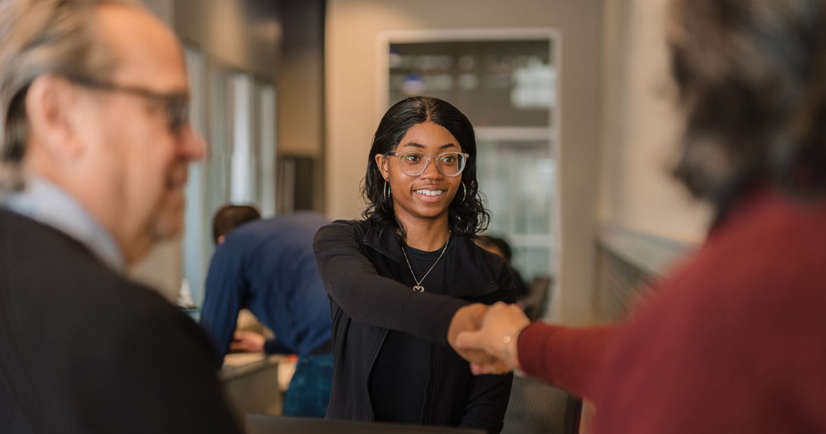 A lake trust team member shakes hands with a member.