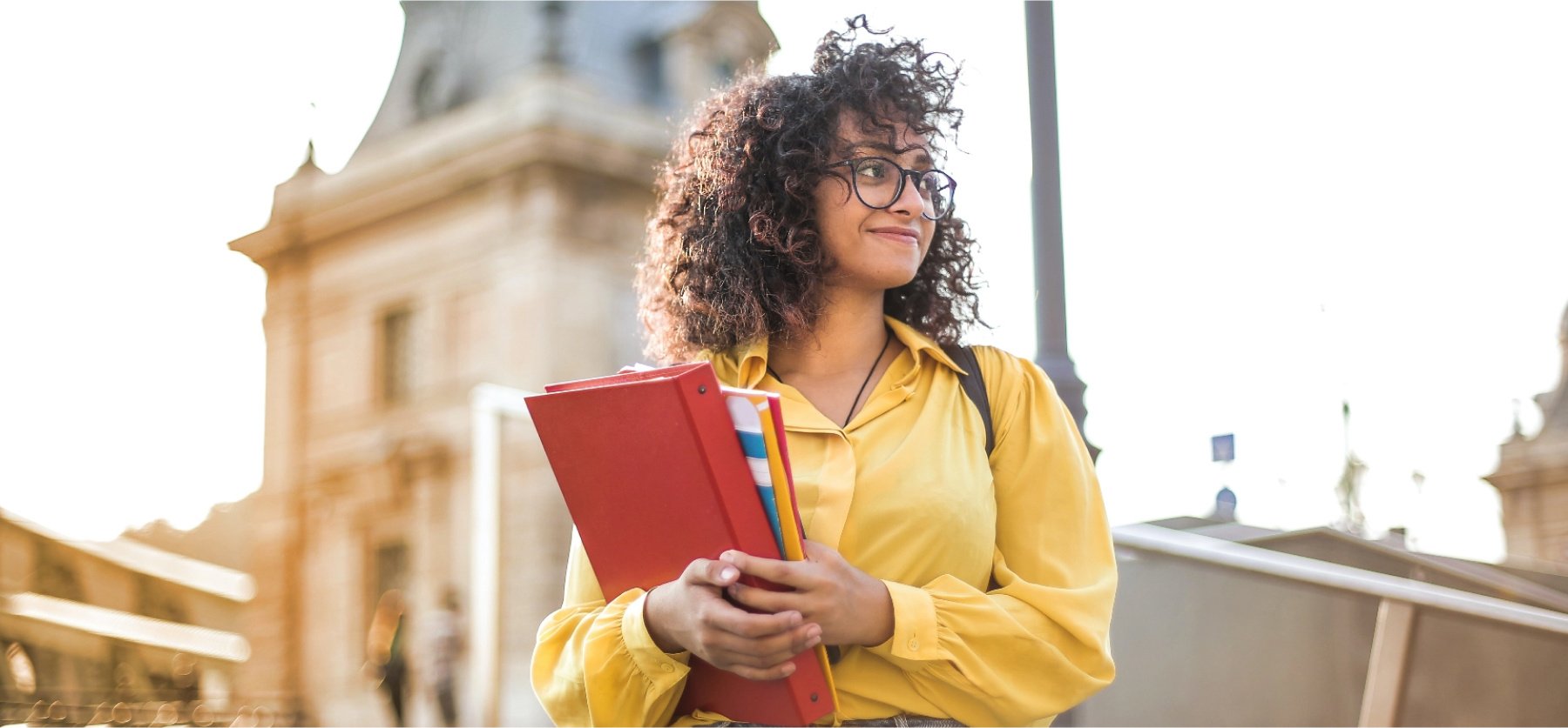 Student standing confidently holding books. 