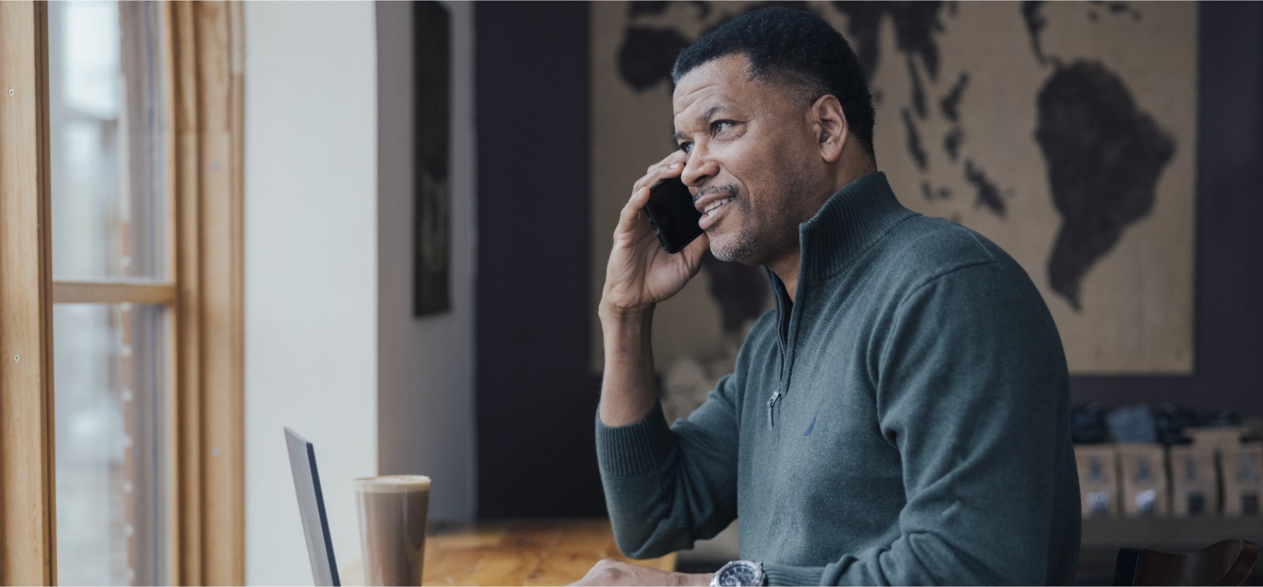 Man on cellphone with laptop open.