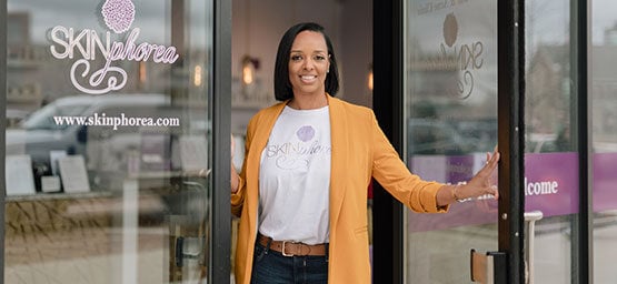 Jessie, small business owner smiling infront of her shop Skinphorea