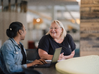 Carolyn, a Lake Trust team member, talks to a colleague