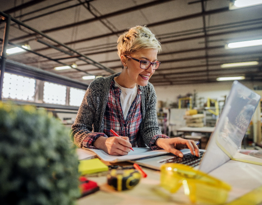 Woman in garage working on laptop. 