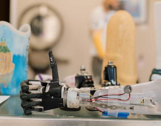 A robotic arm gives a thumbs up sign while resting on a table