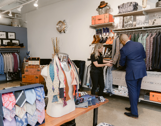 Ne'Gyle, the owner of Bleu Bowtique, shows a suits jacket to a Lake Trust team member