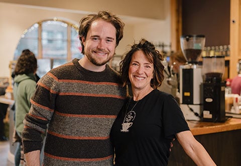 Amy and Spencer, Owners of Brighton Coffeehouse, hugging and smiling