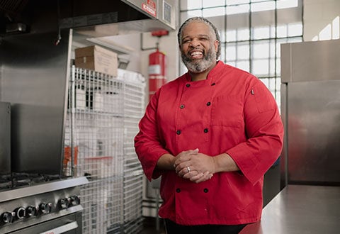 Marcus Leslie smiling standing in a kitchen.