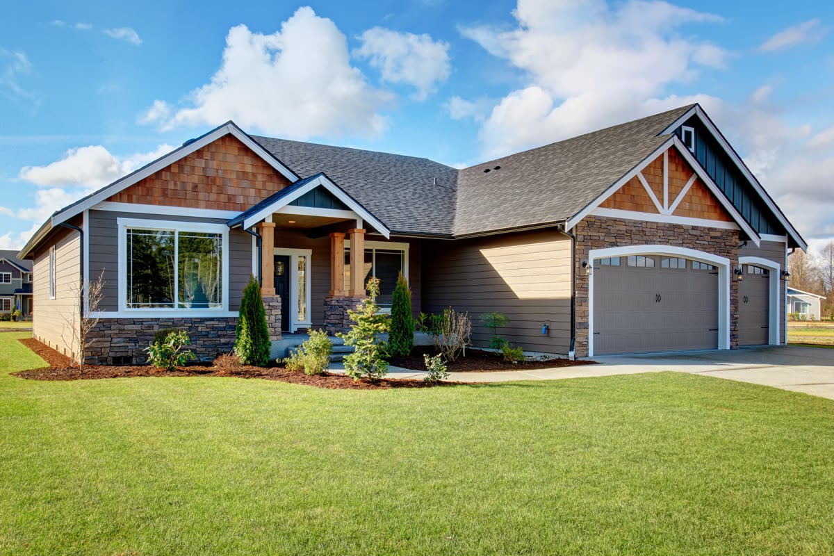 A home with green grass and a blue sky.