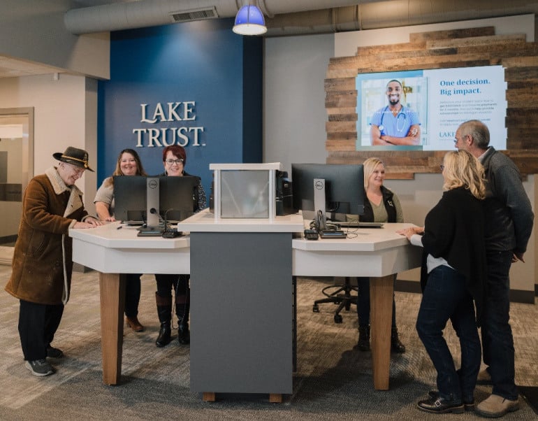 Three Lake Trust team members help three members at a Lake Trust branch