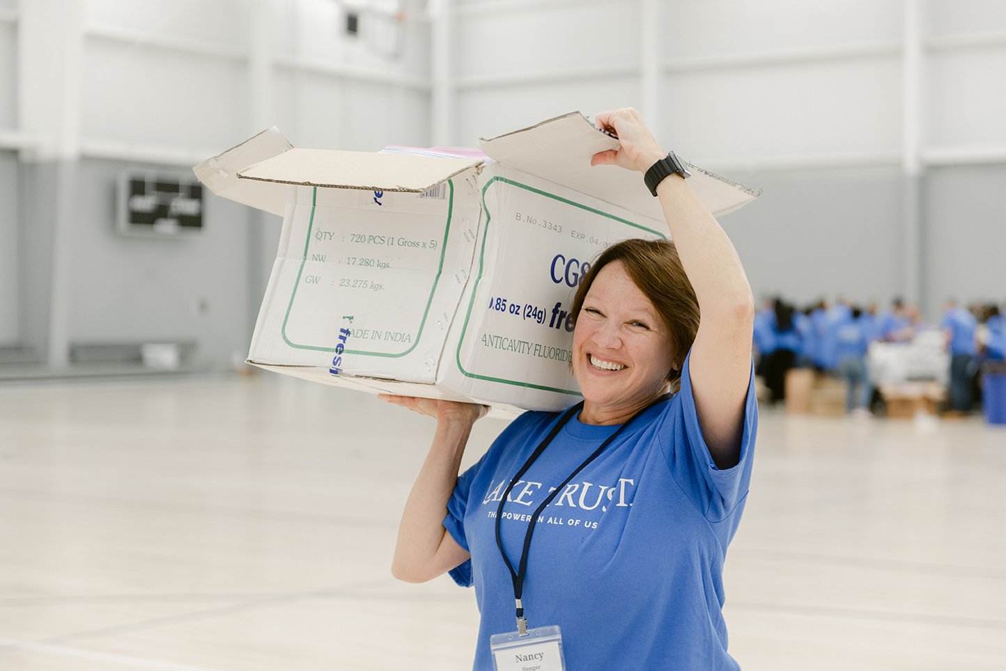 A Lake Trust team member carrying a box at a volunteer event.