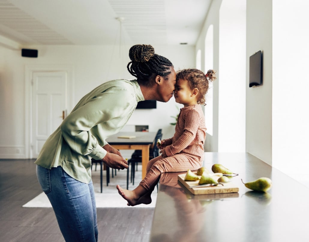 A woman and a child sit in a kitchen