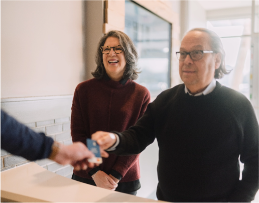 An older couple visit a Lake Trust branch and a team member hands them a debit card