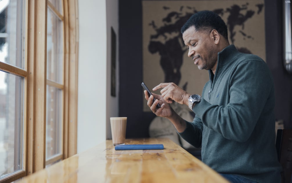 A man texts on his phone at Brighton Coffeehouse