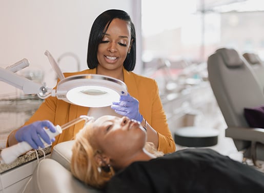 Jessie helping a customer lying in a chair at skinphorea