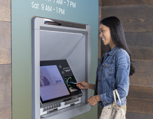 A woman uses a Lake Trust walk-up video teller machine