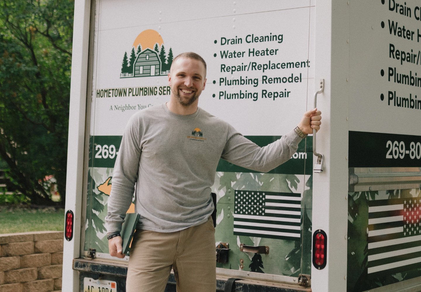 Colton, the owner of Hometown Plumbing, stands in front of his work truck