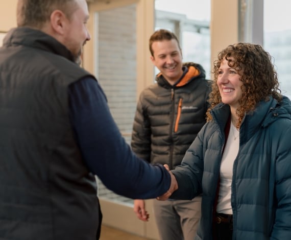 Corey smiles as his wife shakes hands with a Lake Trust team member