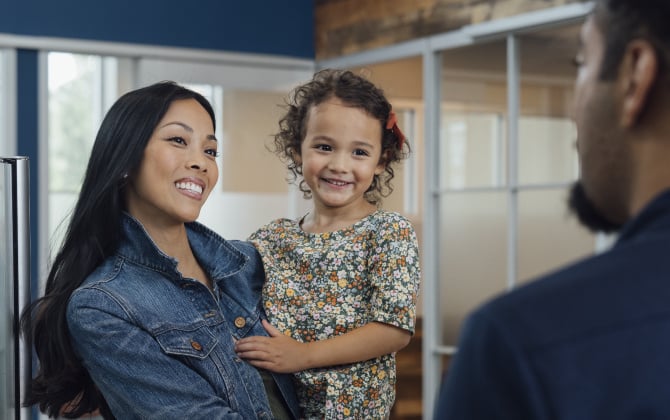 A woman in a jean jacket holding a child