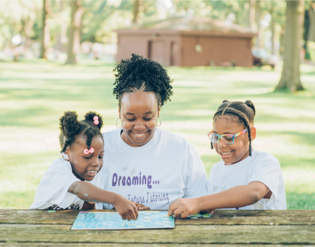 LaToya, a 2019 Lake Trust Foundation Scholarship recipient, tutors two young girls at a picnic table