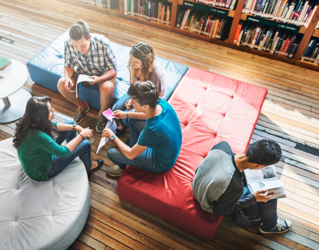 Students gathered in library, reading and chatting. 