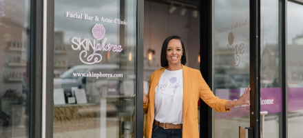 Jessie, small business owner, standing in doorway of her store.