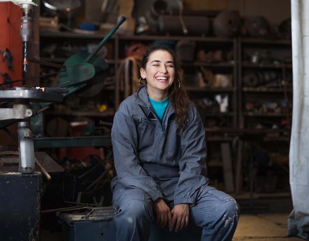 A girl laughs in a workshop