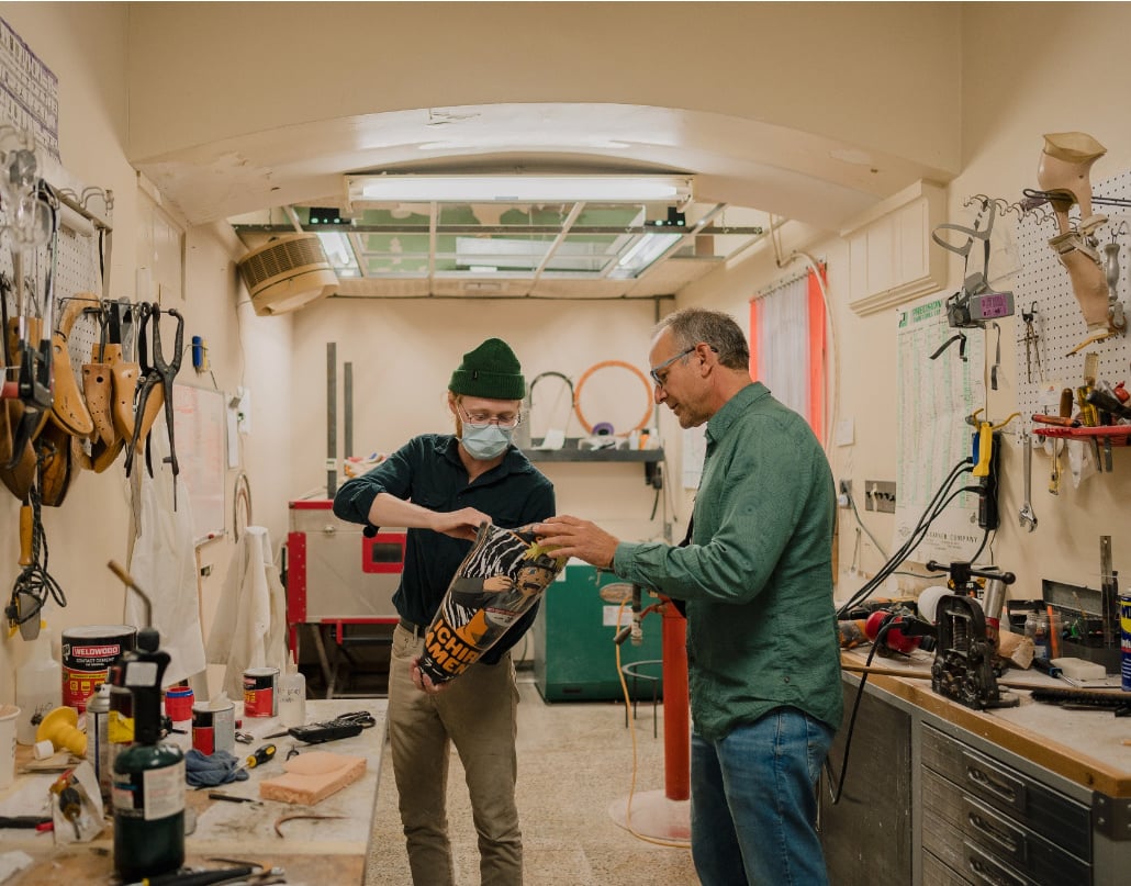 Chris and an employee at Anew Life Prosthetics and Orthotics in Detroit look at a prosthetic leg