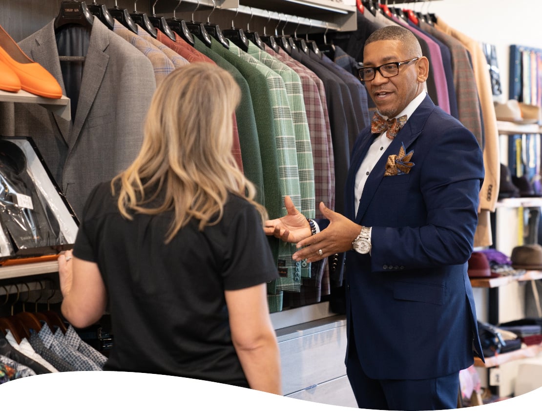 Business owner, Ne'gyle, showing customer options in his boutique in Detroit.